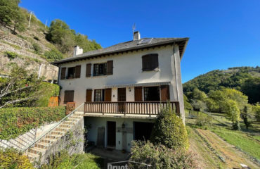 Ensemble immobilier de deux maisons, garages et terrain en bordure de rivière..