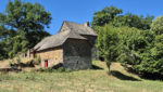 Ensemble immobilier en pierre, isolé, sur plus d'un hectare de terrain.